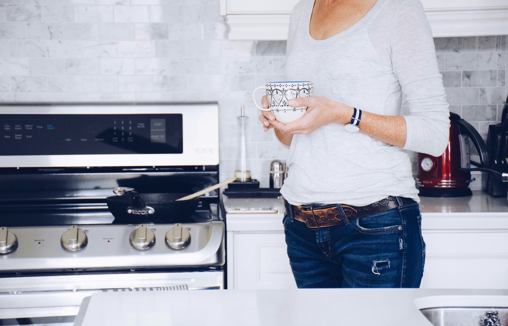 Woman is holding a cup of coffee in a kitchen, morning routine